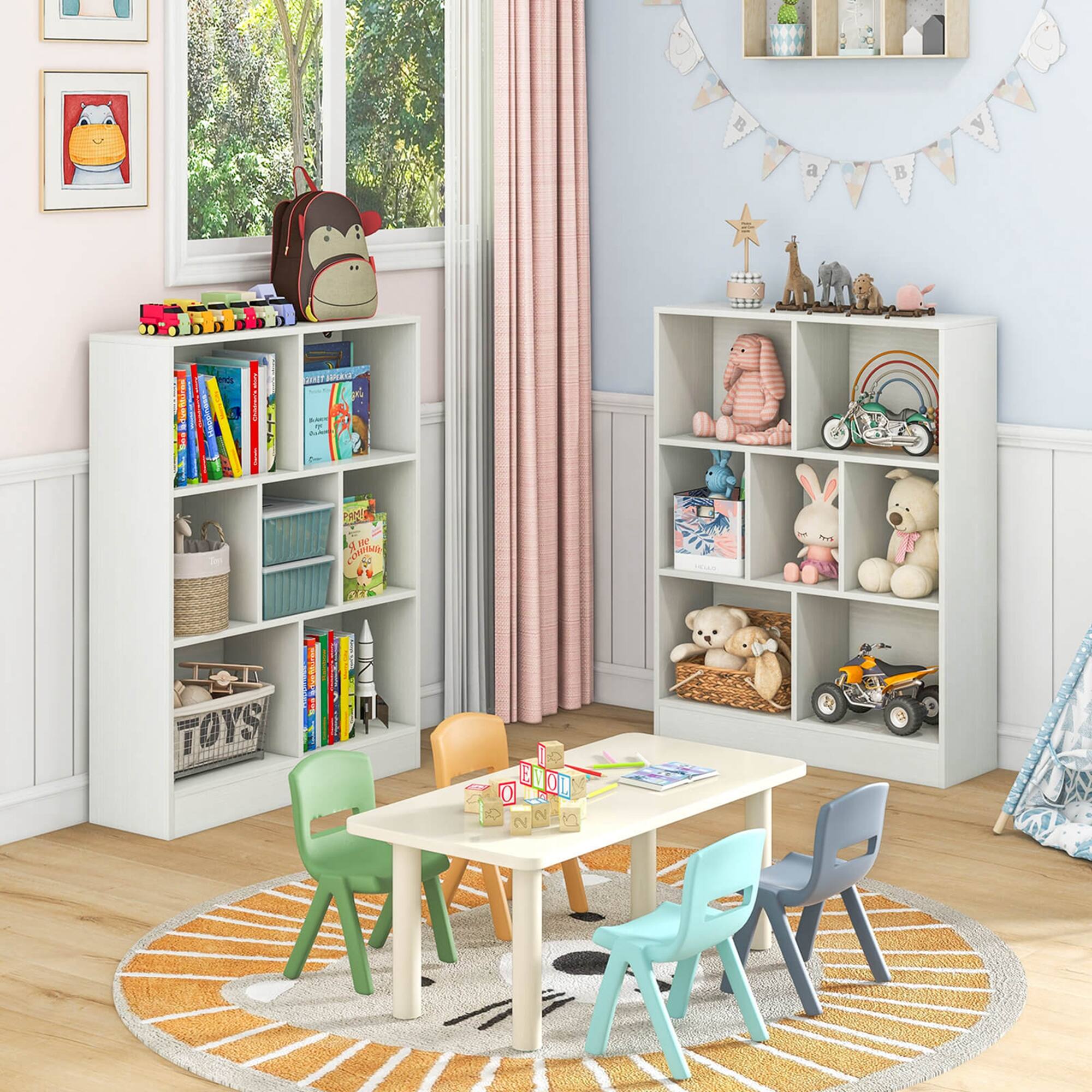 A child's room with a table and chairs, surrounded by bookshelves filled with books and toys. The table is set up for playtime and has a rug underneath it. The room also features a window and a curtain.