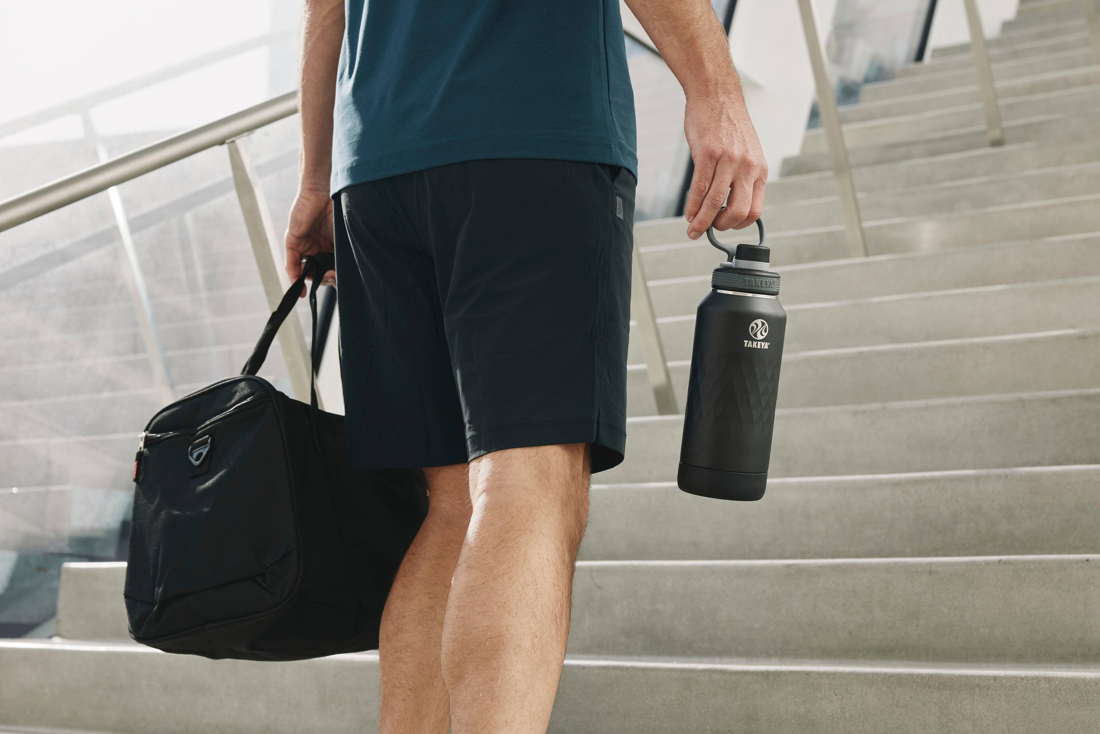 The man is carrying a water bottle and a bag.