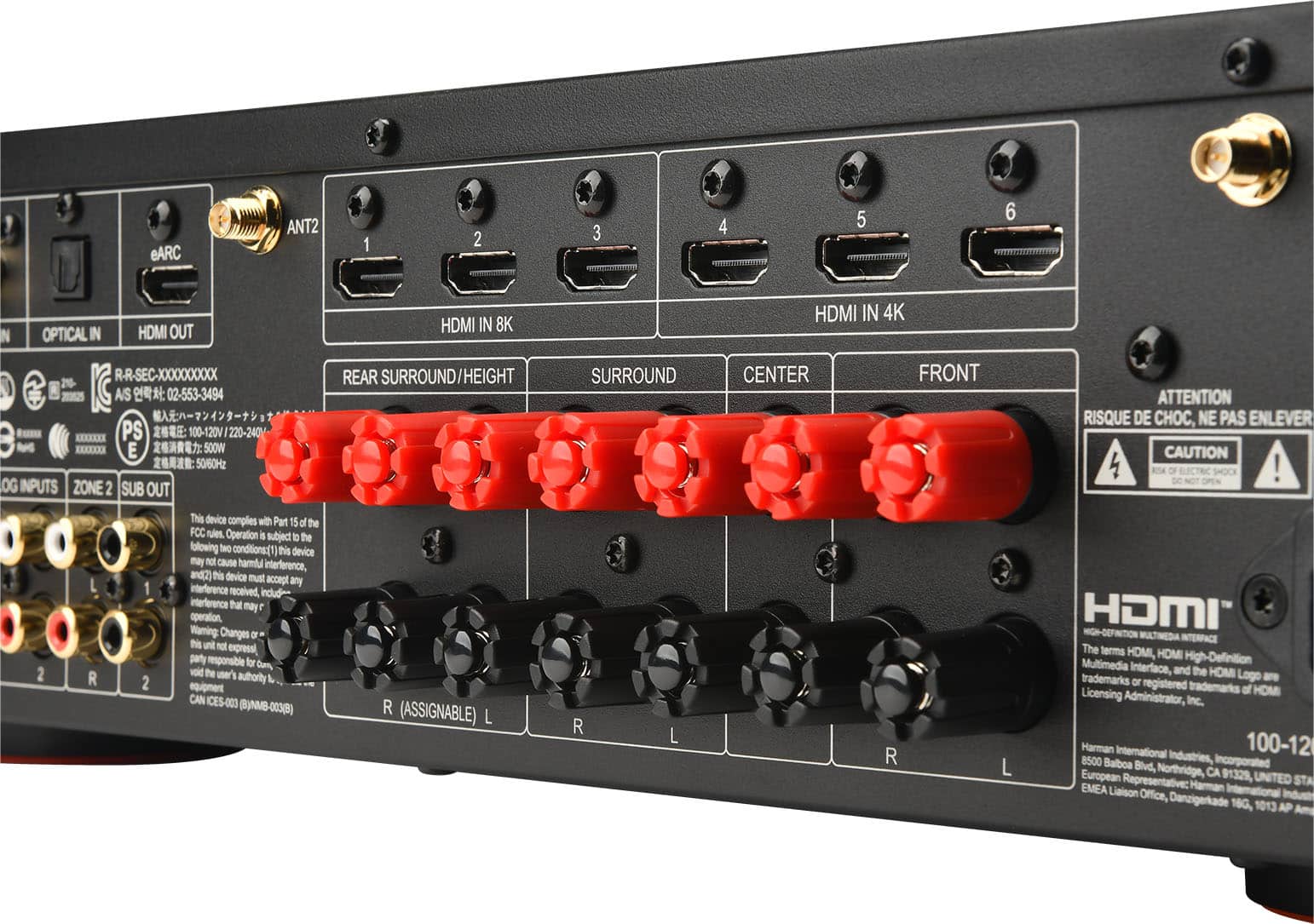 The image features a black electronic device with a row of red buttons on the front. The device is a home theater system with various ports, including HDMI in and out, an optical input, and an RCA input. The device also has a subwoofer output and a zone sub output. The back of the device has a label that reads "RISQUE DE CHOC, NE PAS ENLEVER" which translates to "Risk of injury, do not remove." The device is designed to comply with Part 15 of the FCC rules and is intended for use with HDMI-definition multimedia interface. The terms "HDMI" and "HOMI" are registered trademarks of HOM Licensing Administrator, Inc.