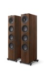The text on the image reads "FAE ml a -  - kore." However, it is not clear what this text represents or its relevance to the image. The image features two large wooden speakers or towers, which are the main focus of the scene.