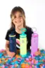 A young girl is holding two colorful Takeya water bottles.