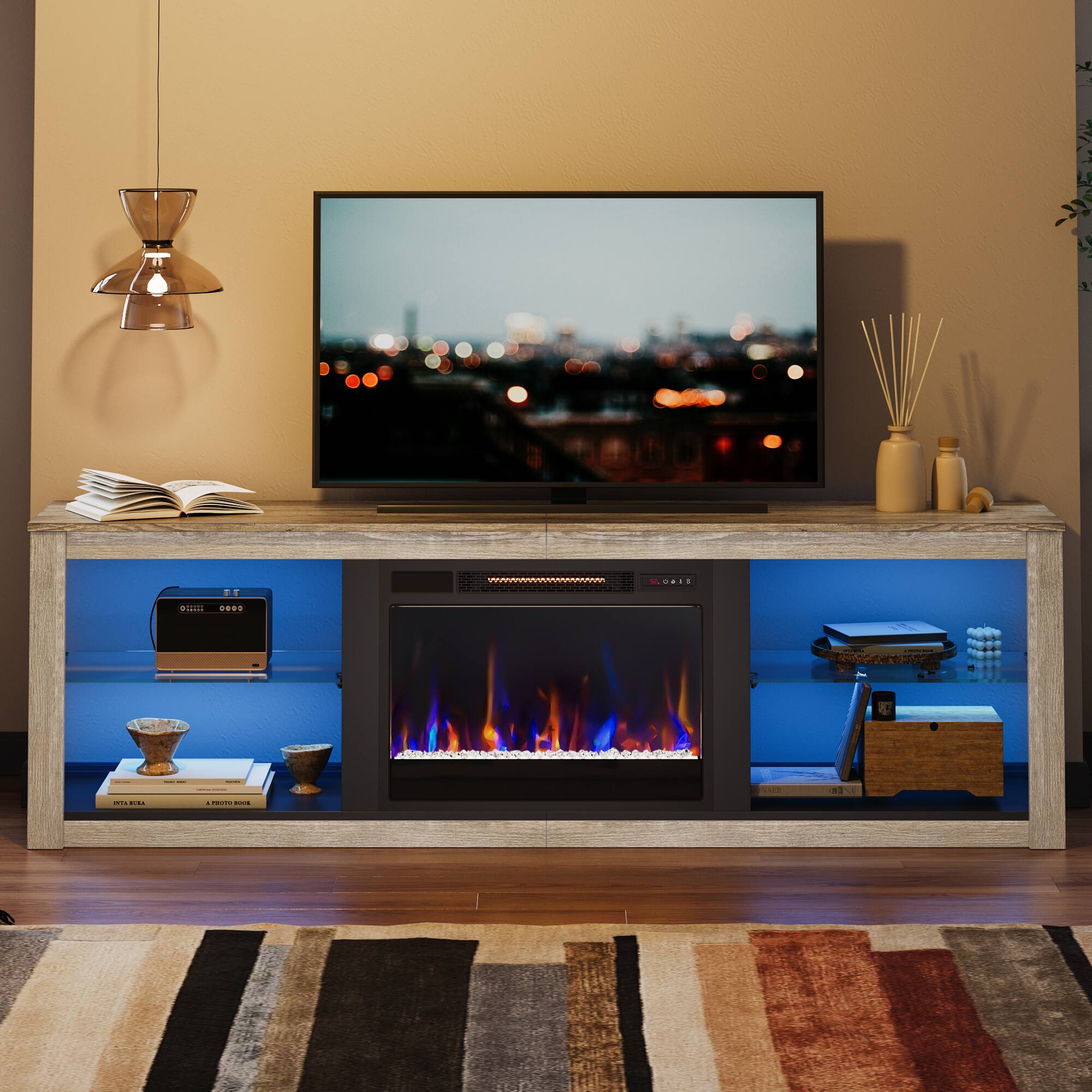 The image shows a living room with a flat screen TV on top of a fireplace. The TV is turned on, and there are several books and a remote control nearby. The room also features a coffee table with a vase on it. The overall setting suggests a cozy and comfortable atmosphere for relaxation and entertainment.