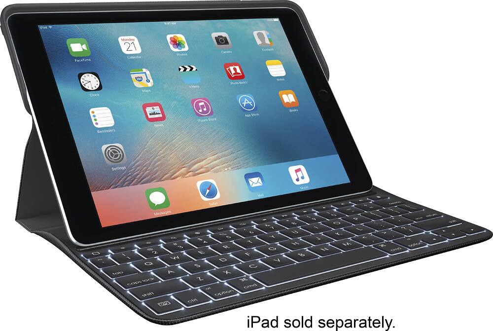 The image features a tablet computer with a keyboard attached to it. The tablet is turned on and displaying the home screen with various icons, including FaceTime, Calendar, Photos, Contacts, Clock, Maps, Videos, Photo Booth, Notes, Reminders, News, iTunes Store, and Settings. The tablet is placed on a stand, and the keyboard is positioned in front of it, making it a convenient setup for typing and using the tablet. The image also includes a caption stating that the iPad is sold separately.