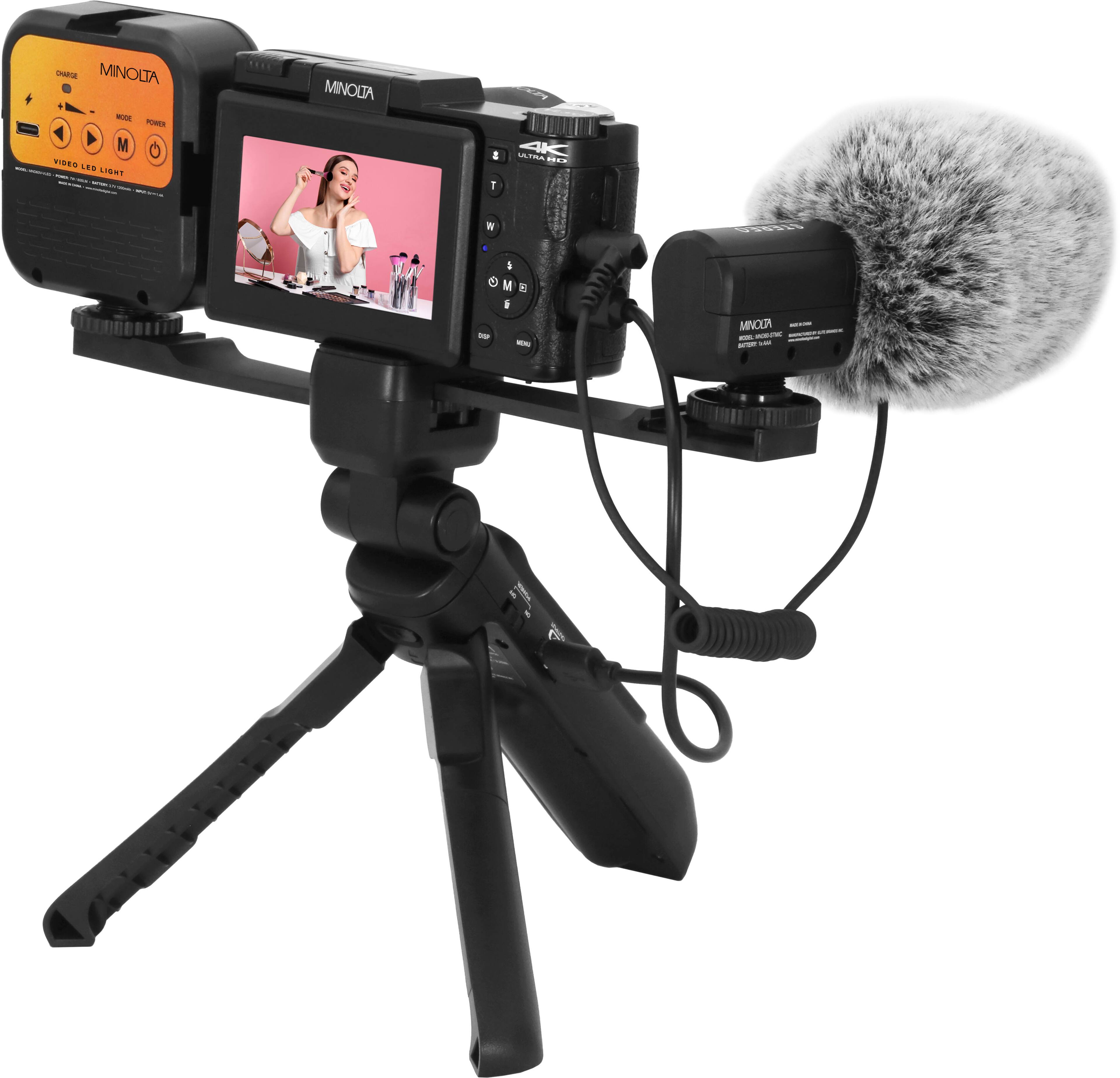 A Panasonic camera is set up on a tripod, with a microphone attached to it. The camera is displaying a picture of a woman on its screen.