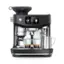 The image shows a black coffee maker with a digital display and a coffee bean grinder. The coffee maker is filled with coffee beans and has a cup of coffee on top of it. The coffee maker is also equipped with a frother, which is used to create a foamy texture for the coffee. The coffee maker is made by Breville, a well-known brand in the coffee-making industry.