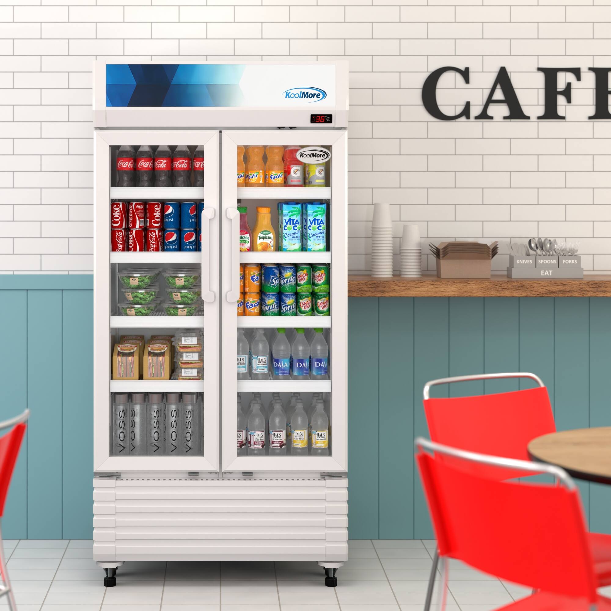 Coca-Cola vending machine with a variety of drinks inside. The machine is located next to a table with chairs. The table is set with silverware, including forks and spoons.