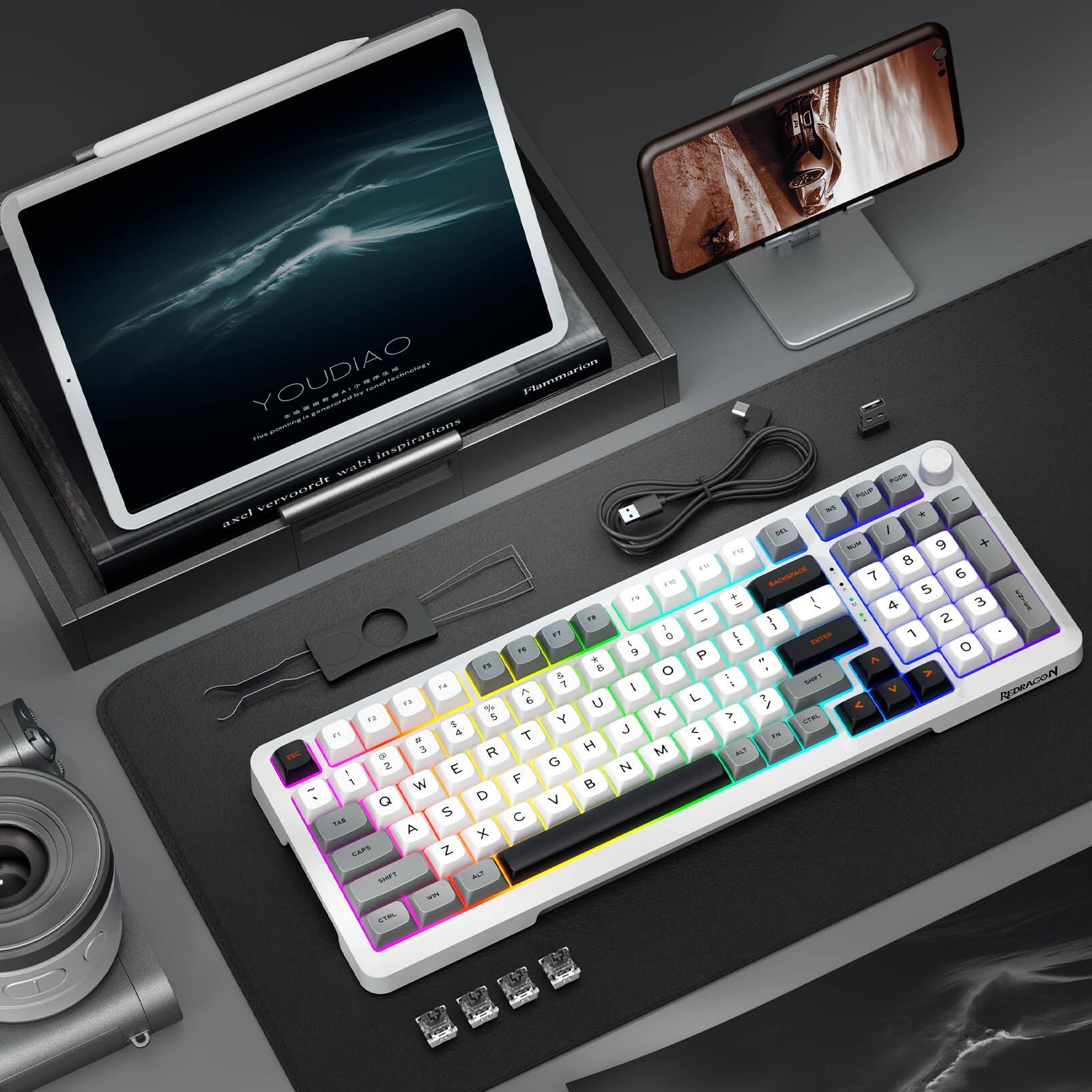 Sure, here is the corrected and grouped text from the image:

---

**Top Left (Tablet Screen):**
- YOUDIAO
- The sound of inspiration
- axel verwoorde wali inspirations

**Bottom Left (Keyboard):**
- RENEGADE

**Bottom Right (Phone Screen):**
- (Image of a person with a blurred face)

**Bottom Center (Keyboard):**
- (Various keys with RGB lighting)

**Bottom Left (Camera):**
- (Camera with a lens)

**Bottom Center (Cables and Accessories):**
- (Cables and small components)

--- 

This text is extracted from the visible parts of the image.