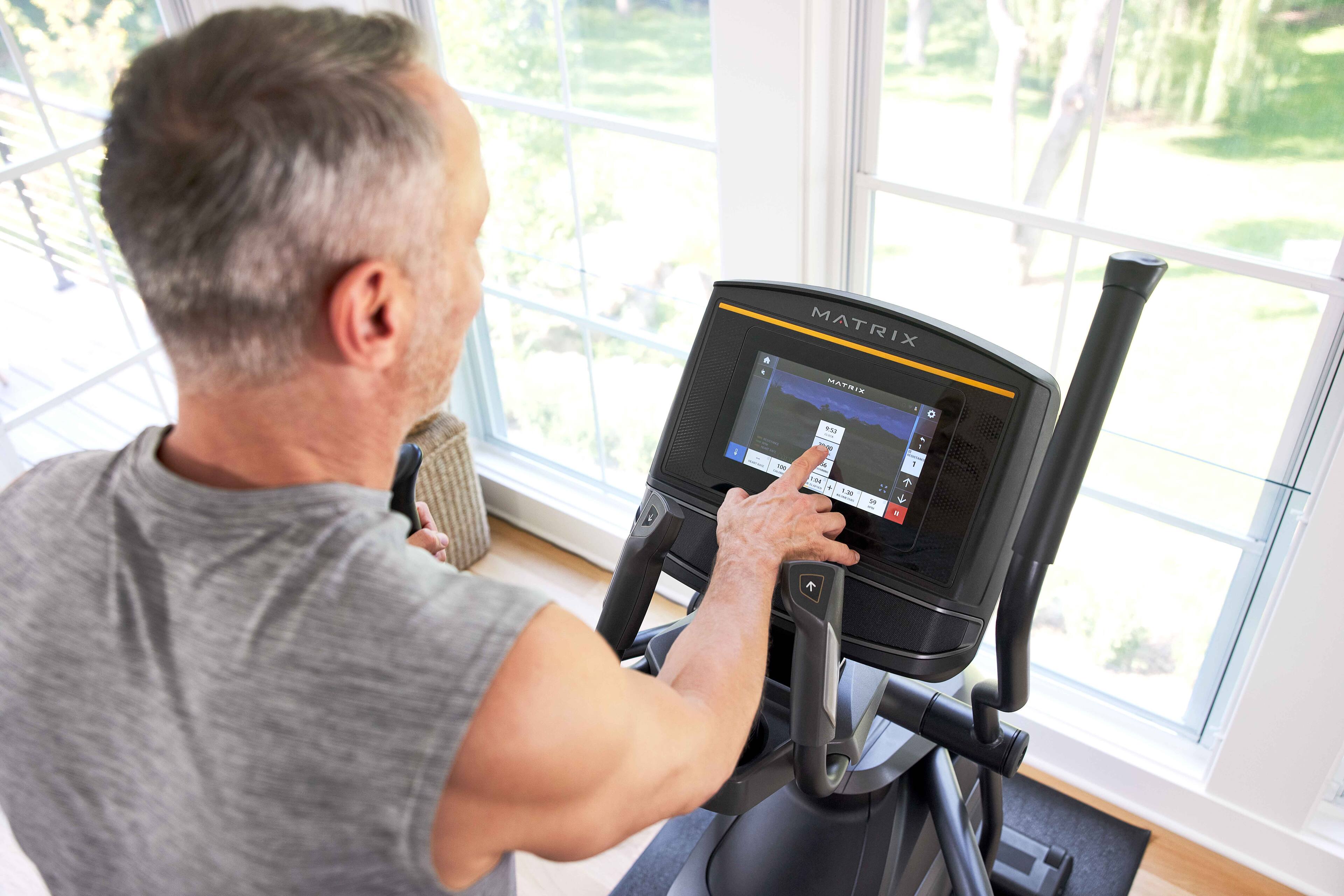 The text on the image reads "iMatrix MATNIR FS I - a - - - - a - + 1 - S J - 9". This text appears to be a description or instructions for the man using the exercise machine.