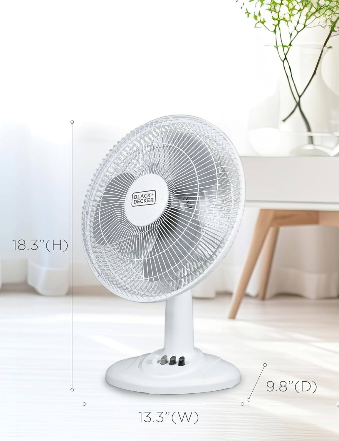 The text on the image reads "BLACK+DECKER 18.3" (H) 13.3" (W) 9.8" (D)". This information indicates the dimensions of the white fan in the image. The fan is 18.3 inches tall, 13.3 inches wide, and 9.8 inches deep.