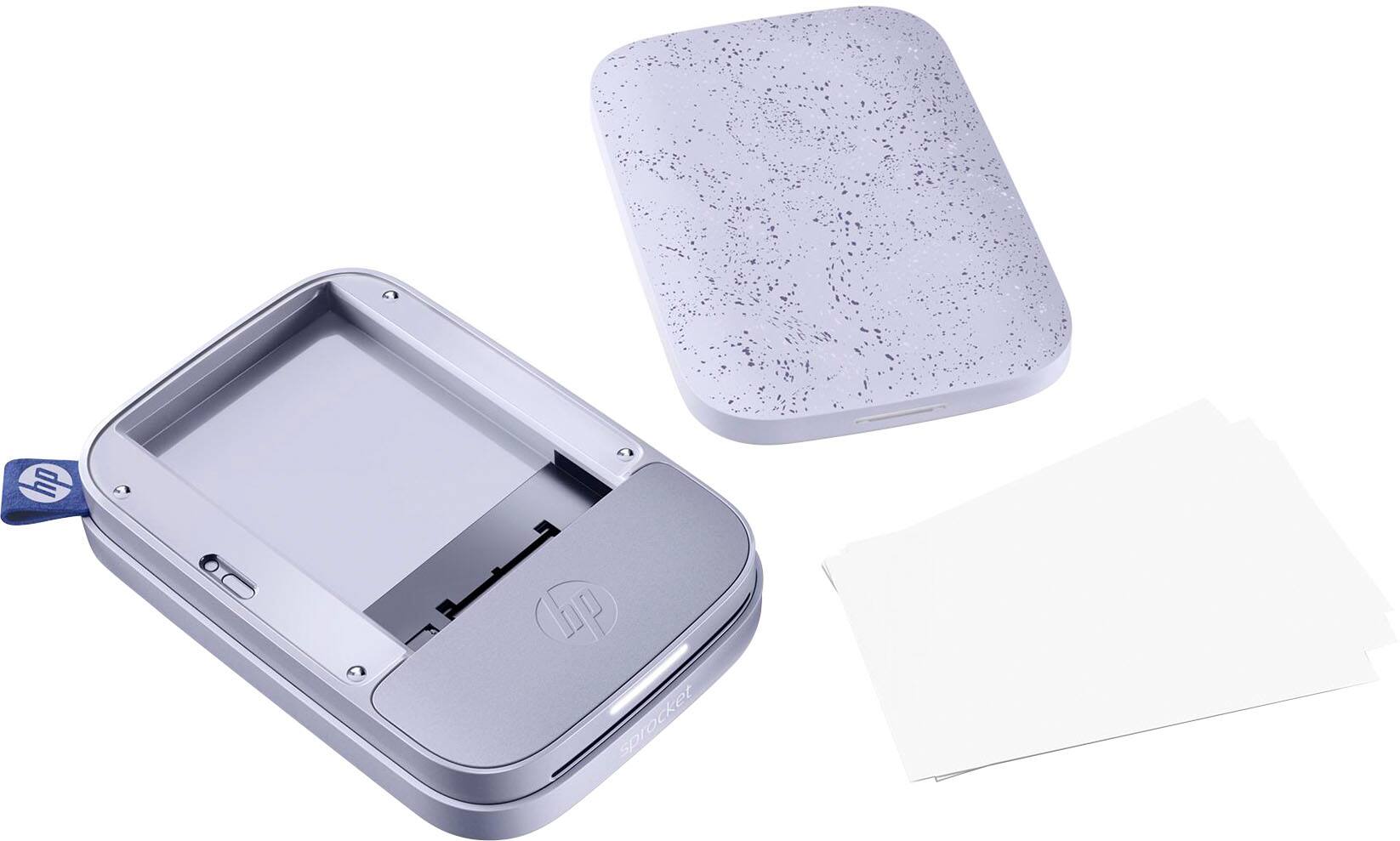 The image features a HP branded device, which appears to be a printer or a similar electronic device. The device is sitting on a white surface, and there are two pieces of paper nearby. One of the pieces of paper is a white envelope, while the other is a piece of paper with a purple design on it. The overall scene suggests that the device might be used for printing or processing these papers.