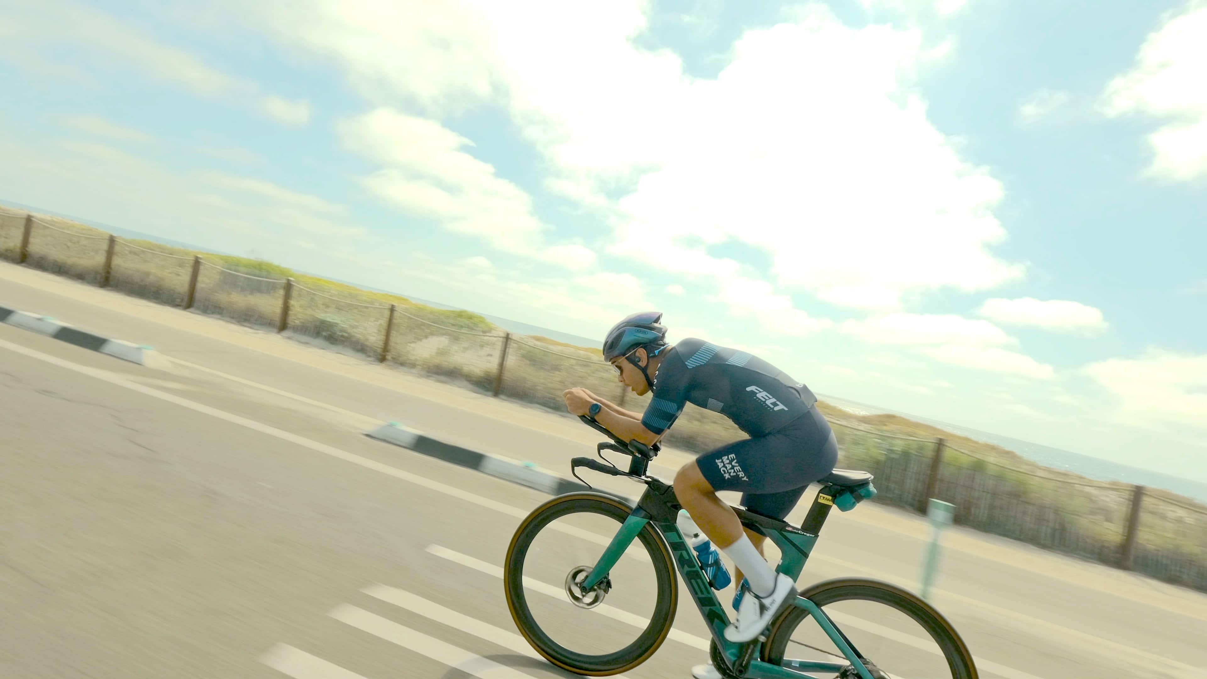 Felt Jack is riding a bicycle down a street.