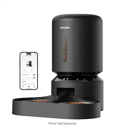 The image features a Petlibre coffee maker and a phone, with the phone being sold separately. The coffee maker is black and has a container of coffee beans. The phone is placed next to the coffee maker, and the two items are positioned in front of a wall.