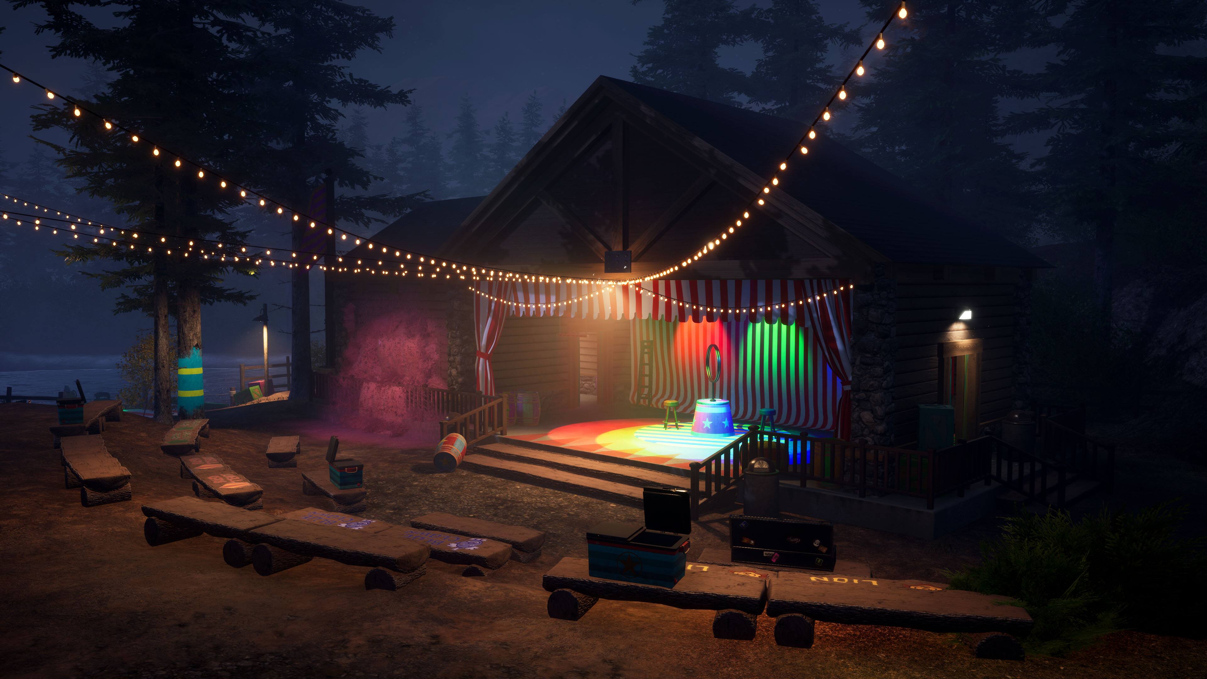 "Add NDIT NEE" is not a valid grouping or correction. The image shows a night scene with a house, a stage, and a few benches. The stage has a rainbow curtain, and there are lights strung up above the stage. The setting appears to be a campground or a similar outdoor venue.