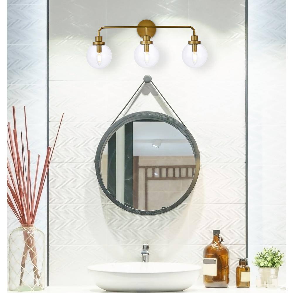 Angle. Living District - Hanson 3 lights bath sconce in brass with clear shade - Brass And Clear Shade.