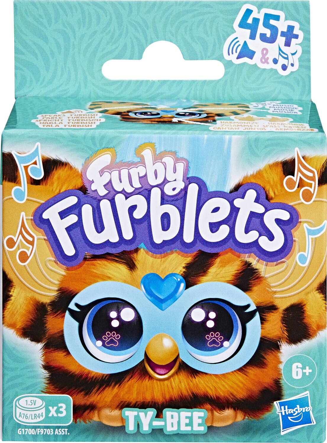 Sure, here is the corrected and grouped text from the image:

---

**Furby Furblets**

**TY-BEE**

**45+ & Music**

**SPEAKS FURBISH**  
**PARLE FURBISH**  
**HABLA FURBISH**  
**FALA FURBISH**

**HARMONIZE**  
**HÄRKONIZE**  
**ZUSAMMEN SPASS HABEN**  
**CANTAN JUNTOS**  
**ARMONIZAR**

**6+**

**1.5V A76/LR44 x3**

**G1700/F9703 ASST.**

**Hasbro**

---