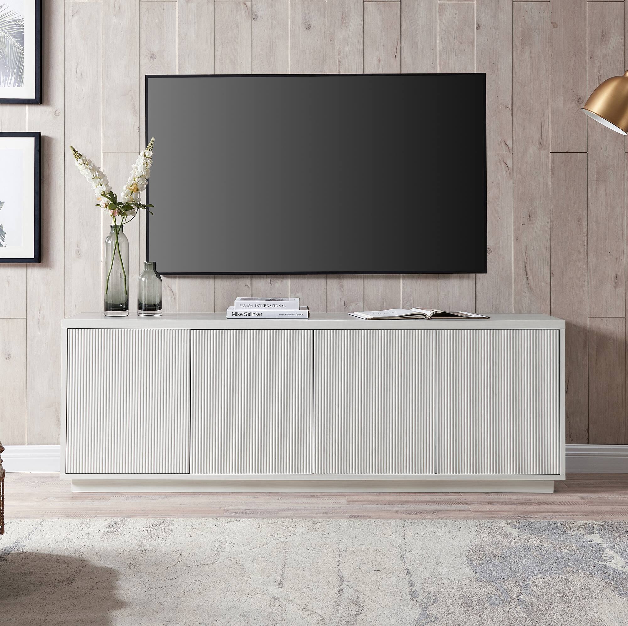 I cannot group or correct the text as it does not appear to be related to the image. The image shows a living room with a flat screen TV on top of a wooden cabinet, a vase with flowers, and a book on a table.