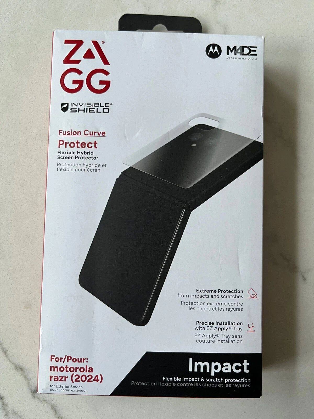 ZAGG  
INVISIBLE SHIELD  

Fusion Curve  
Flexible Hybrid Screen Protector  
Protection hybride et flexible pour écran  

MADE  
MADE FOR MOTOROLA  

Extreme Protection  
from impacts and scratches  
Protection extrême contre les chocs et les rayures  

Precise Installation  
with EZ Apply® Tray  
EZ Apply® Tray sans couture installation  

For/Pour:  
motorola razr (2024)  
for Exterior Screen  
pour l'écran extérieur  

Impact  
Flexible impact & scratch protection  
Protection flexible contre les chocs et les rayures
