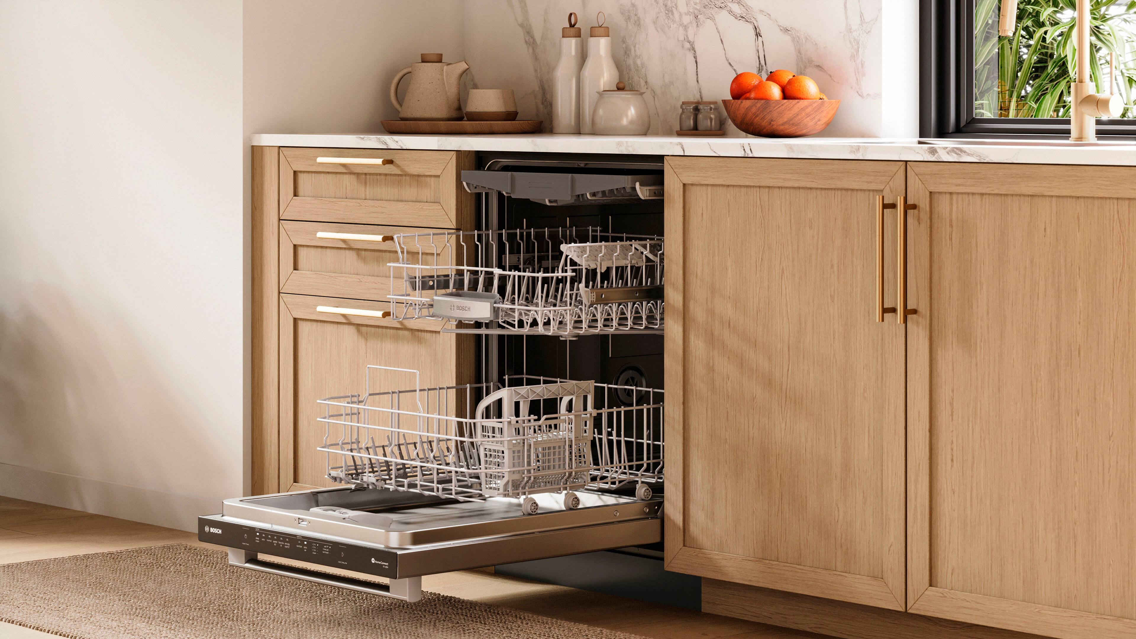 The image shows a kitchen with a dishwasher and a dish rack. The dishwasher is located under the counter, and the dish rack is placed on the counter. There are several dishes, including cups and bowls, placed on the counter and in the dishwasher. Additionally, there are oranges and a potted plant visible in the scene.