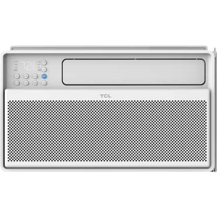 The image features a white TCL speaker that is turned on. The speaker has a digital clock on the front, which displays the time as 7:22. The speaker is likely used for playing music or other audio content, and it is placed in a room.