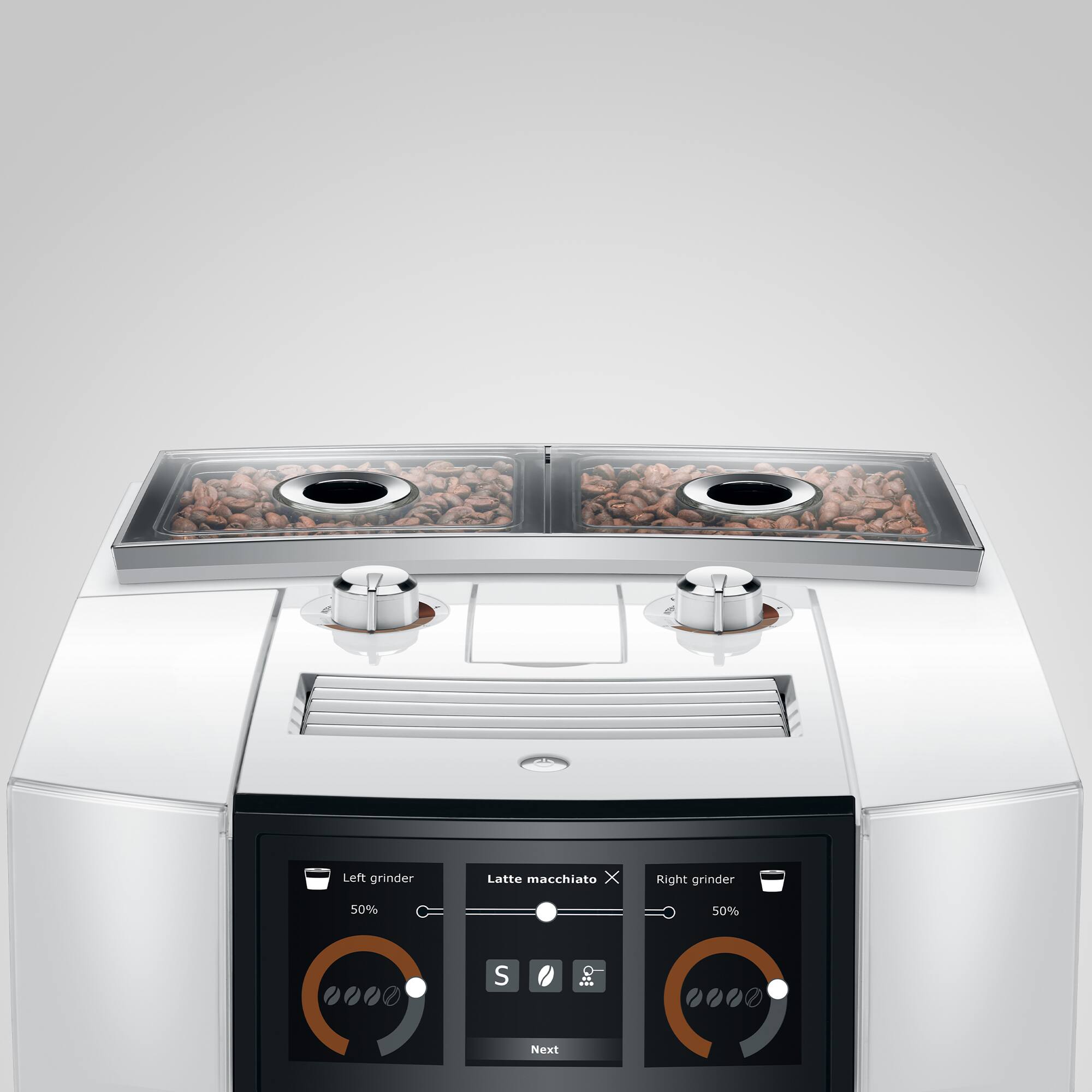 The text on the image reads: "Left grinder Latte macchiato X Right grinder 50% 50%". This suggests that the machine has two grinders, one for Latte macchiato and the other for a 50/50 blend. The machine is designed to prepare coffee drinks with different ratios of espresso and milk, catering to various preferences.