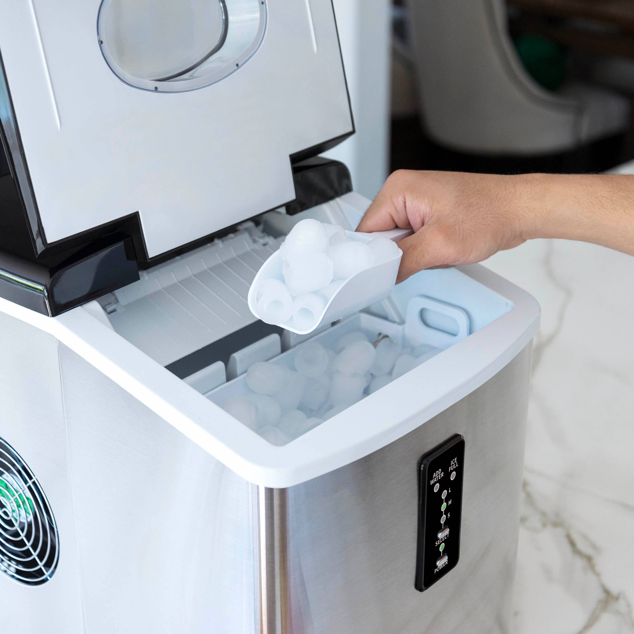 A person is putting ice cubes into a machine.