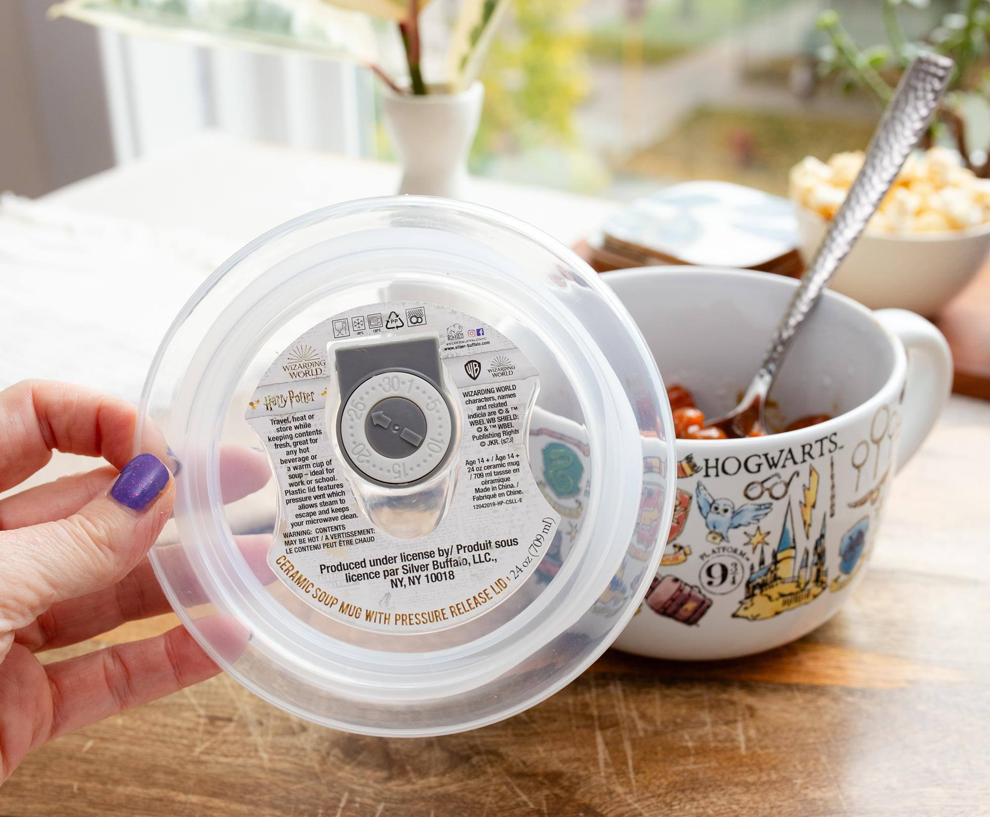 **WIZARDING WORLD**  
Harry Potter

**WARNING: CONTENTS MAY BE HOT**  
LE CONTENU PEUT ÊTRE CHAUD

**CERAMIC SOUP MUG WITH PRESSURE RELEASE**  
Produit sous licence par Silver Buffalo, LLC.  
NY, NY 10018

**WIZARDING WORLD**  
Harry Potter characters names

**Travel heat or keep warm for up to 12 hours**  
Store when not in use.  
Plastic store sleeve allows for easy cleaning.  
Made in China.

**24 oz (709 mL)**

**HOGWARTS**  
91