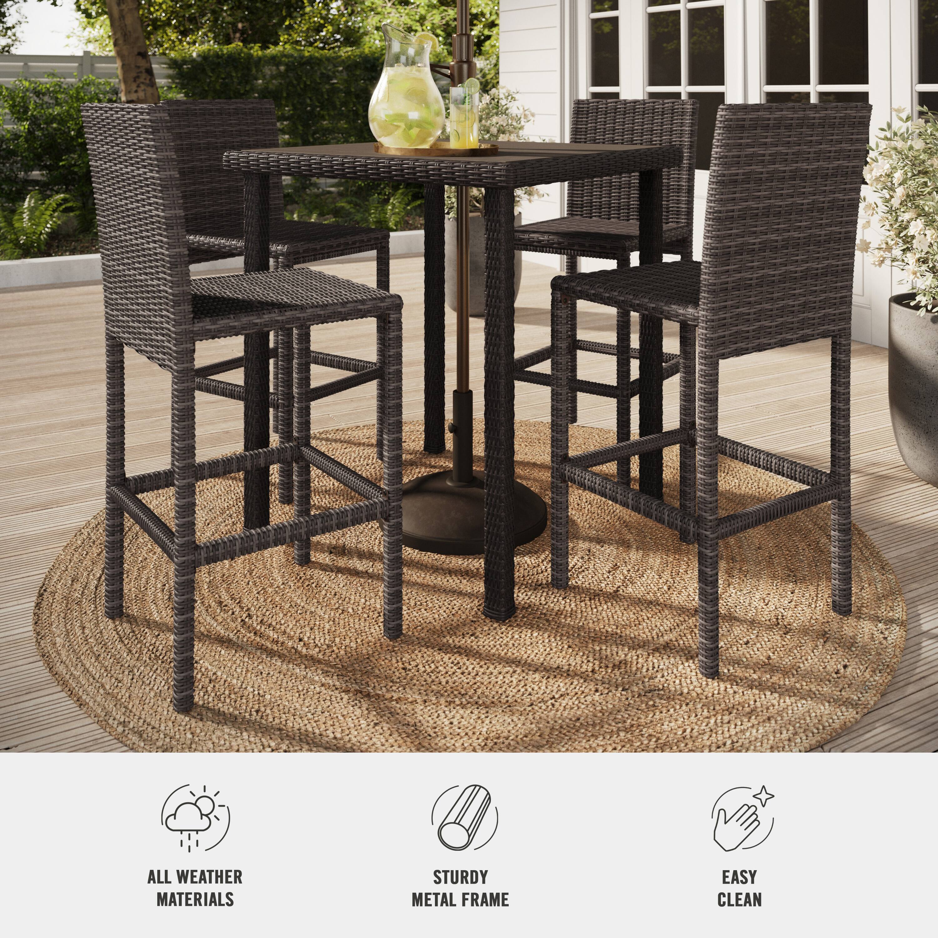 The image features a patio set with a table and four chairs. The table is made of all weather materials and has a sturdy metal frame. The chairs are easy to clean, making it a practical and comfortable outdoor seating arrangement.