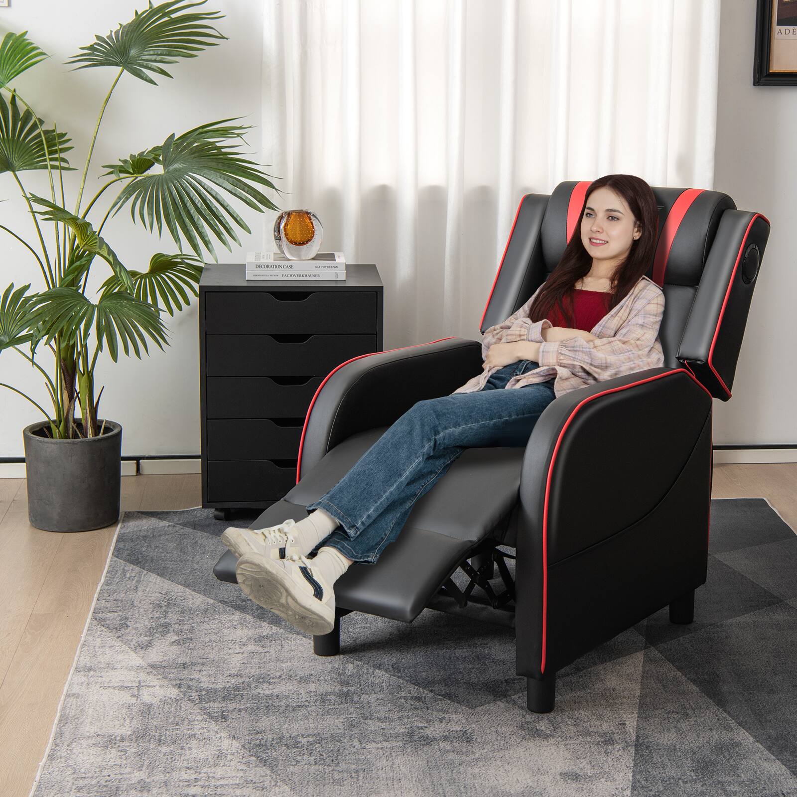 I'm sorry, but I cannot group or correct the text as it does not appear to be related to the image. The image shows a woman sitting in a black recliner chair with a potted plant nearby.