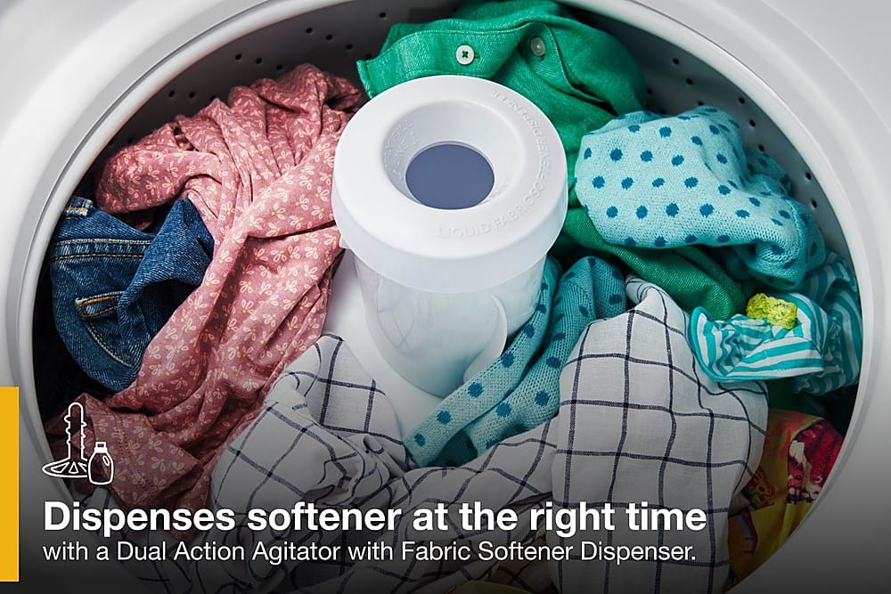 The image shows a washing machine filled with clothes, with a dispenser of softener placed on top of the clothes. The machine is designed to dispense softener at the right time, ensuring that the clothes are soft and comfortable to wear. The dual action agitator with a fabric softener dispenser helps to distribute the softener evenly throughout the clothes, providing optimal results.
