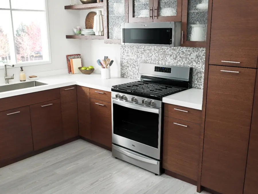 The image shows a microwave with a coffee cup and a coffee mug inside. The microwave is set to 12:20.