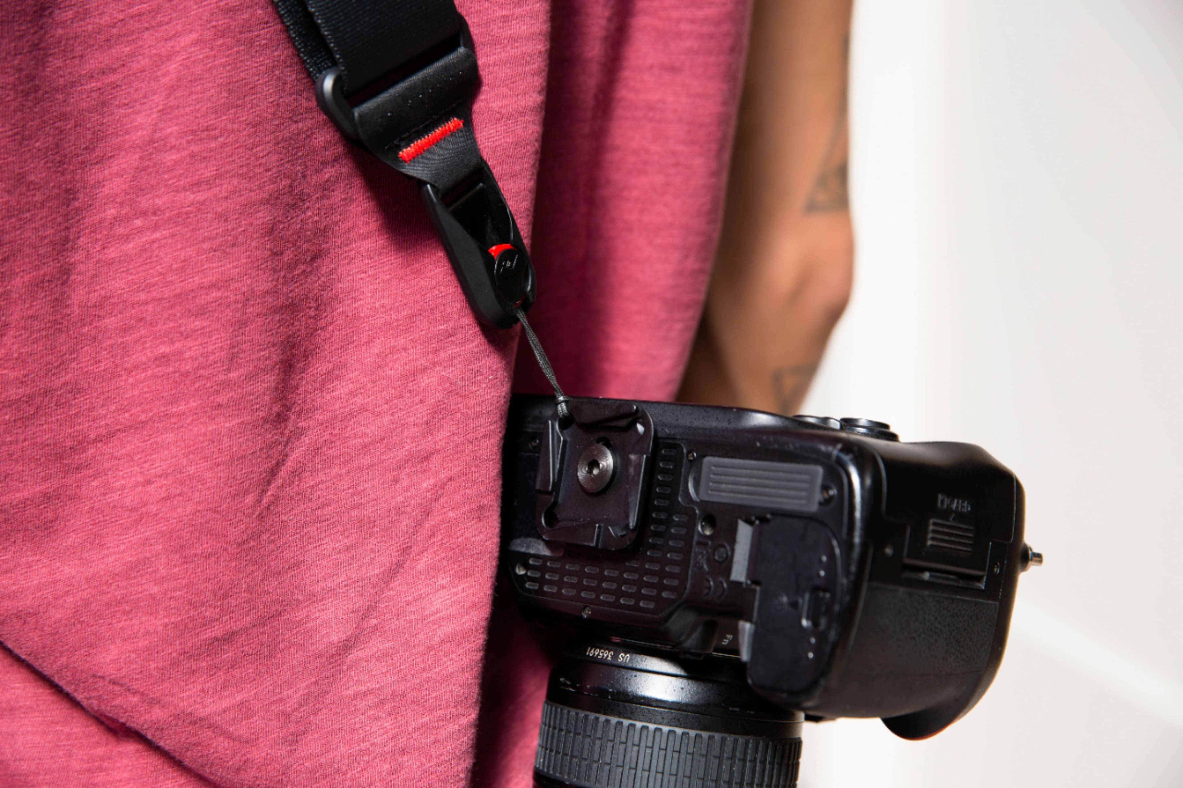 A black camera with a strap attached to it. The camera has a 50mm lens and is capable of shooting in XF Raw format.
