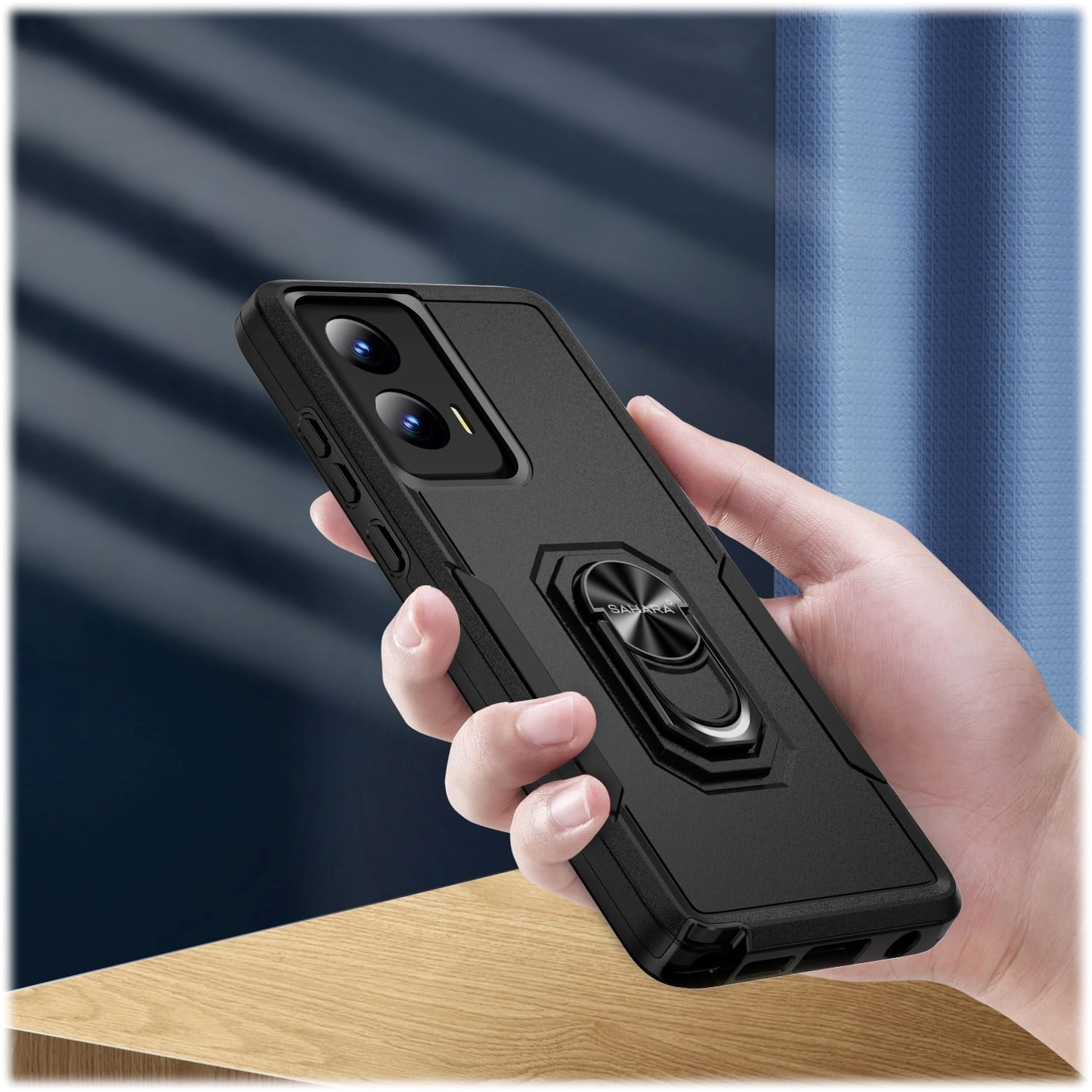 The image features a person holding a cell phone in their hand. The cell phone is placed inside a black case, which is designed to protect the device. The case has a unique feature, a fan on the back, which may serve as a cooling mechanism or a decorative element. The person's hand is visible in the image, and they are likely interacting with the cell phone or adjusting the case.