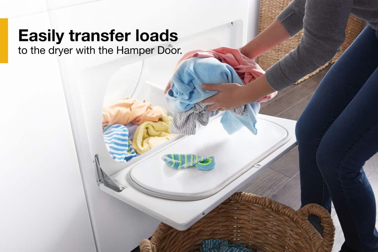 The image shows a person transferring laundry from a washing machine to a dryer using the Hamper Door. The Hamper Door is a convenient feature that allows for easy transfer of loads between the washing machine and the dryer.
