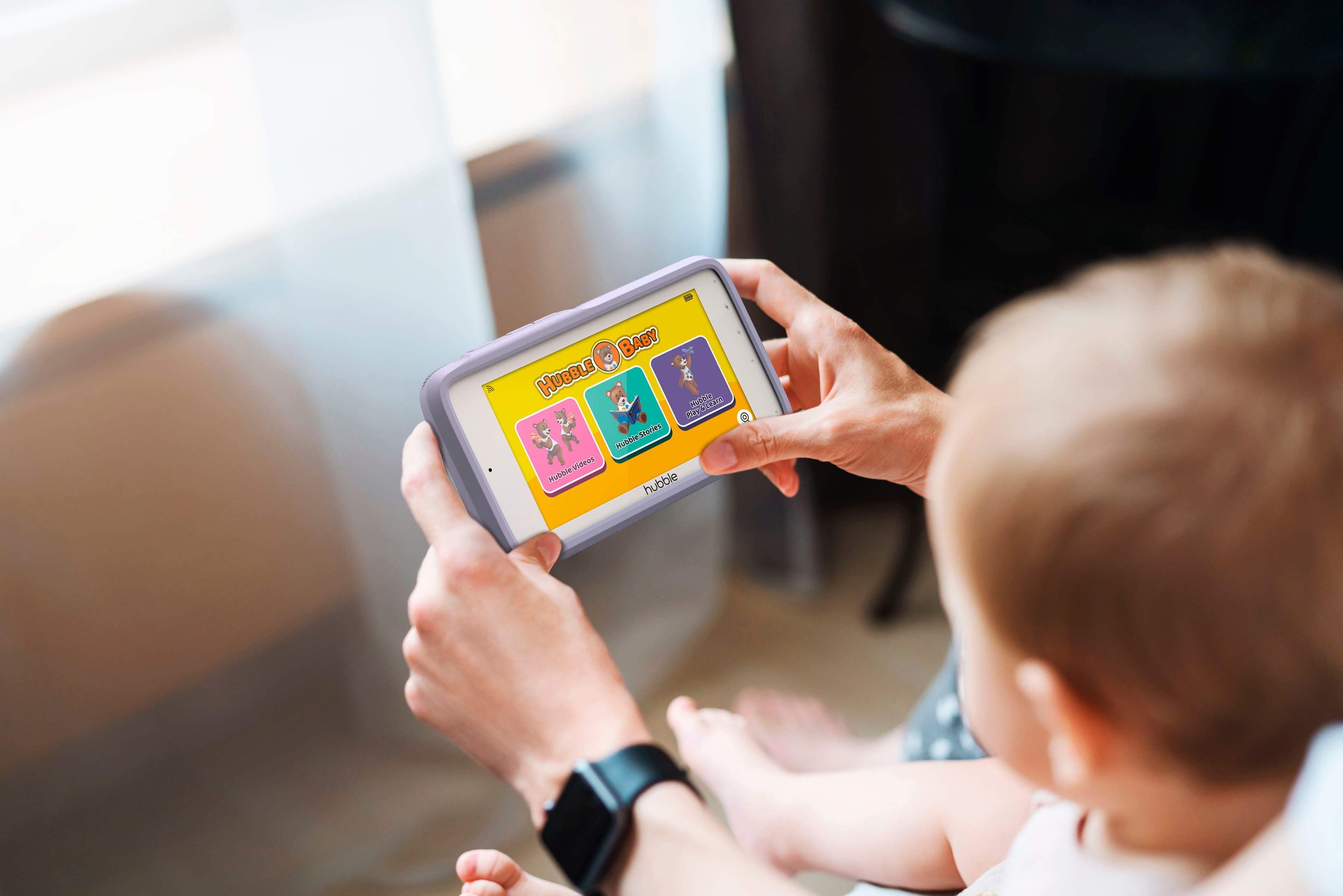 Hubble for Babies is a Hubble-themed educational app designed for babies. The app features various Hubble-themed stories, videos, and games to entertain and educate young children. In the image, a person is holding a tablet displaying the Hubble for Babies app, while a baby is sitting on their lap.
