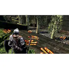 The image features a person wearing a helmet and holding a sword, standing in a dark and eerie environment. The person is surrounded by several fire-like objects, which could be torches or flames, scattered around the area. The scene appears to be a video game setting, possibly a medieval or fantasy-themed game. The person is positioned in the center of the image, with the fire-like objects surrounding them, creating an intense and dramatic atmosphere.
