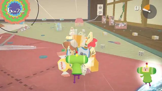 The image shows a video game with a group of characters, including a green character, standing on a pink surface. The game appears to be a colorful and fun environment. The text "6cm 7mm 10cm 1kg 1L 100m" is displayed at the top left corner of the image, possibly indicating the scale or size of the game world. The game appears to be a cartoon-like setting with various characters interacting with each other. - E (Everyone)