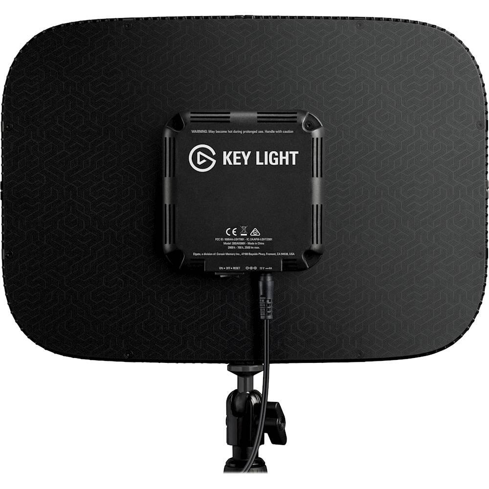 The image features a black Key Light device, which is a portable projector that can be used for various purposes. The device is attached to a black stand and has a cord plugged into it. The Key Light is designed for use in low light conditions, making it a convenient tool for presentations or other situations where a traditional projector might not be suitable.