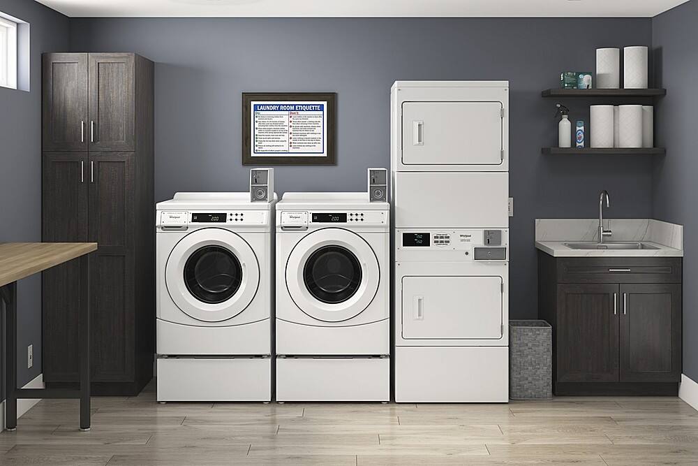 The image features a laundry room with a washer and dryer. The washer is located on the left side of the room, while the dryer is positioned on the right side. There is also a sink in the room, which is situated near the dryer. The laundry room is equipped with a TV mounted on the wall, providing entertainment while doing laundry. The room is clean and well-organized, with a table nearby for placing items during the laundry process.