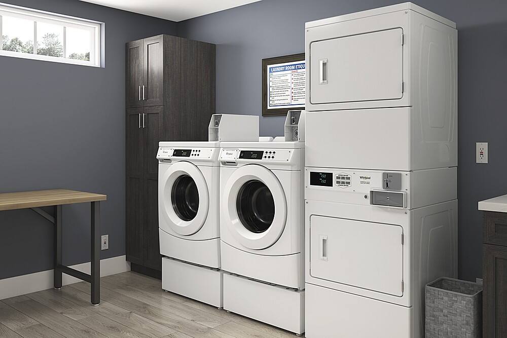 The image shows a laundry room with two washing machines and a dryer. The room is clean and well-organized, with the machines placed next to each other. The washing machines are of different sizes, with one being larger than the other. The dryer is located nearby, completing the laundry setup. The room appears to be well-maintained and ready for use.