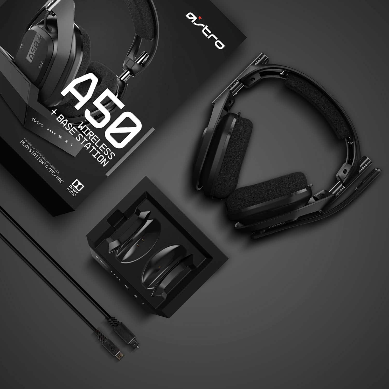 The image features a pair of Astro A50 wireless headphones, which are designed for use with the PlayStation 4 gaming console. The headphones are displayed in a box, and they come with a base station that connects to the console. The headphones are equipped with Dolby 7.1 surround sound technology, providing an immersive gaming experience. The headphones are also compatible with PC and Mac devices, making them versatile for various gaming and entertainment needs.