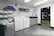 The image features a laundry room with a washer and dryer, a sink, and a shelf with towels. The room also has a gym area with a treadmill and a bench. The sign on the wall states "Gym Rules."
