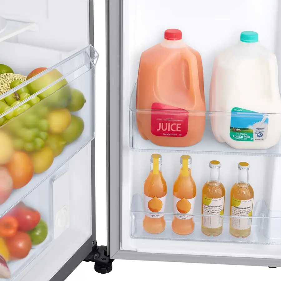 The image shows a refrigerator with two shelves. The top shelf contains a gallon of milk and a jug of orange juice. The bottom shelf contains a variety of fruits and vegetables, including apples, oranges, and bananas. There are also several bottles of juice stored in the refrigerator, adding to the assortment of items.