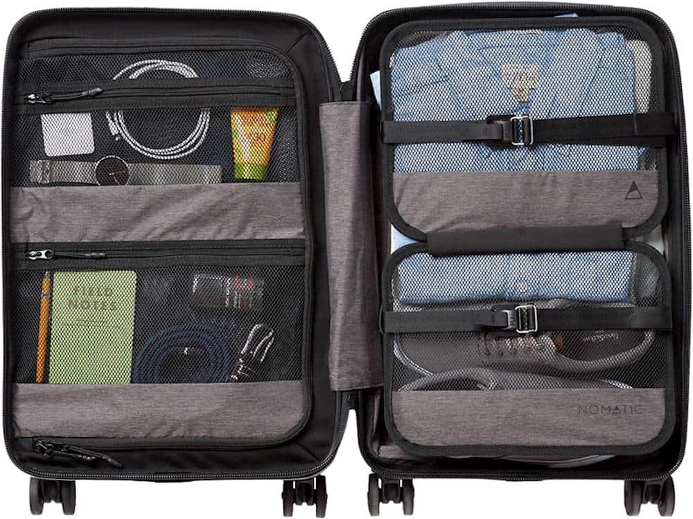 The image shows a suitcase with its contents exposed, revealing a variety of items such as a book, a pair of jeans, a toothbrush, and a cell phone. The suitcase is open, allowing the viewer to see the various belongings inside. The items are neatly organized, making it easy to locate and access them when needed. The suitcase is likely used for traveling or storage, providing a convenient way to keep belongings organized and easily accessible.