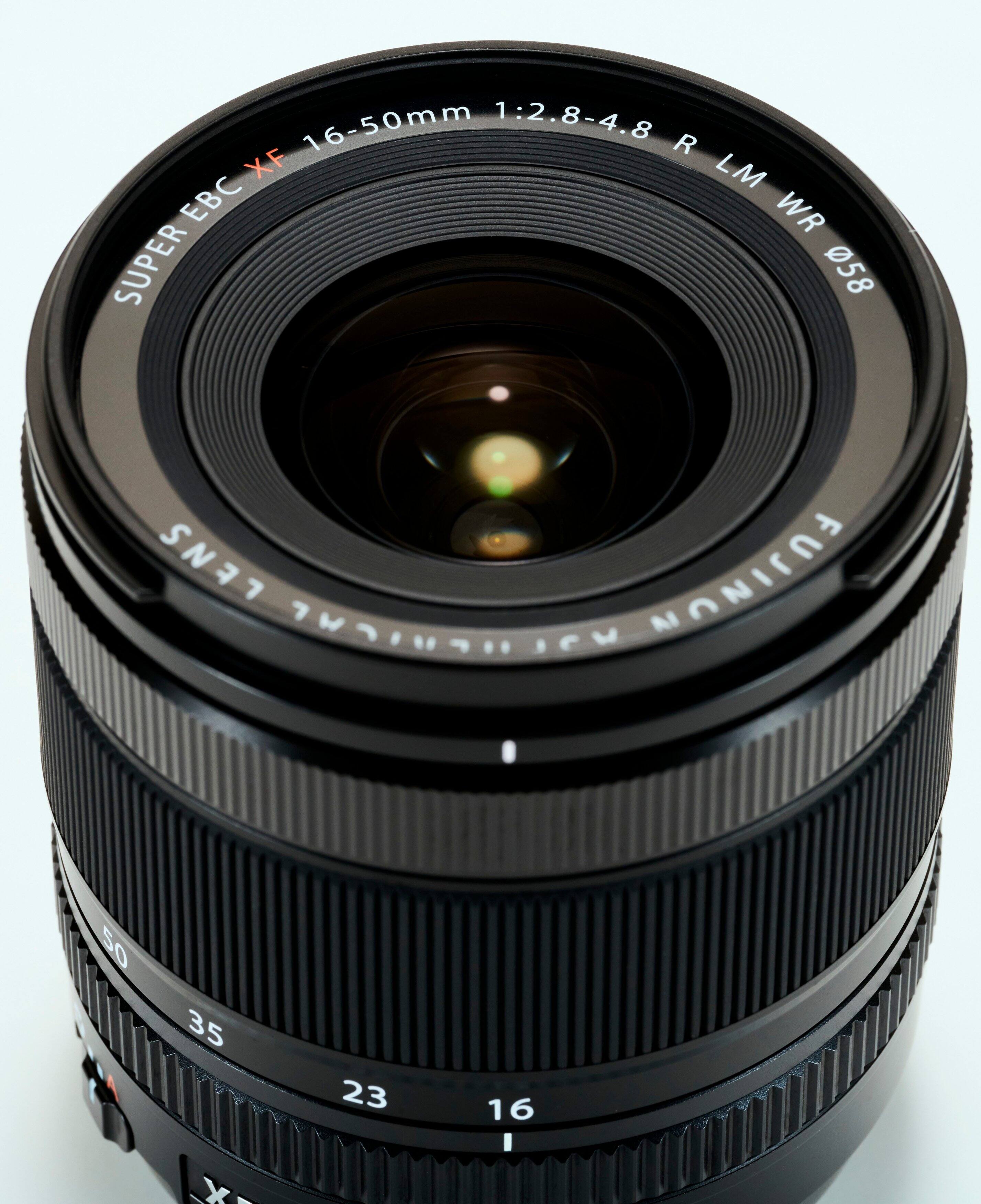 The text on the image reads: "16-50mm 1:2.8-4.8 R XF LM EC WR SUPER 058 LENS FUJINON MAC 50 35 23 16 x-." This text is likely describing the specifications of the lens, such as its focal length, aperture, and compatibility with different camera systems.