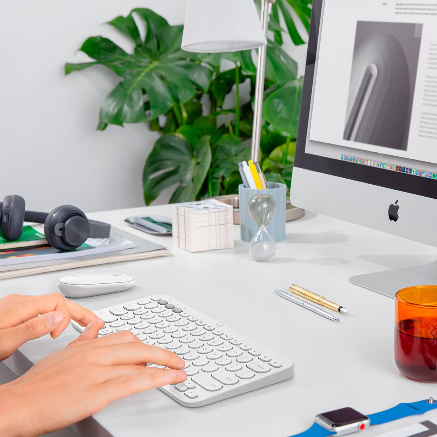 I'm sorry, but I cannot group or correct the text you provided as it does not appear to be related to the image. The image shows a person using a computer with a keyboard and a monitor, along with a potted plant and a cup nearby.
