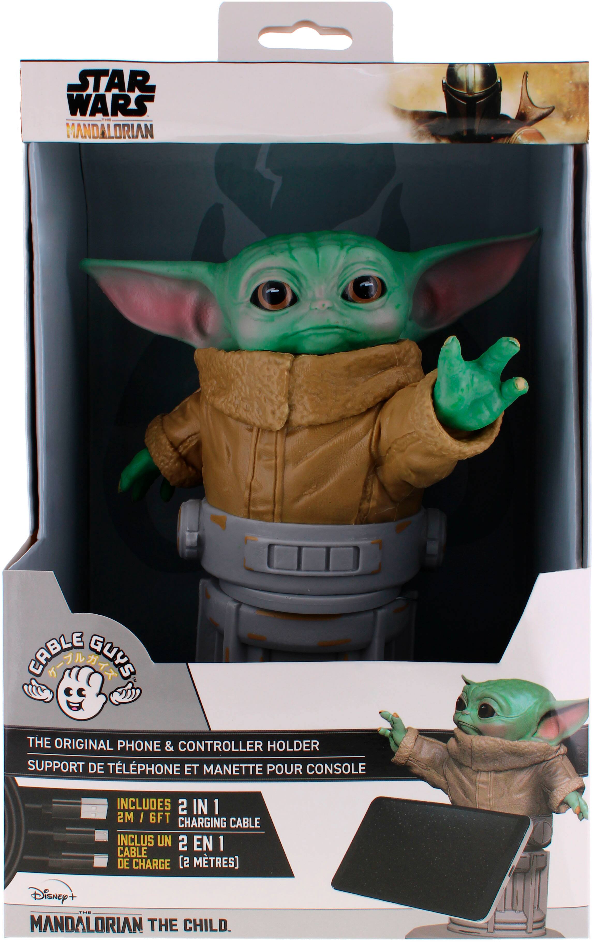 The image features a Star Wars action figure of the Mandalorian, also known as "The Child," which is a popular character from the Star Wars franchise. The figure is posed in a way that it appears to be holding a cell phone and a remote control. The packaging of the figure includes a 2-in-1 charging cable, making it a convenient and functional toy for fans of the Star Wars series.