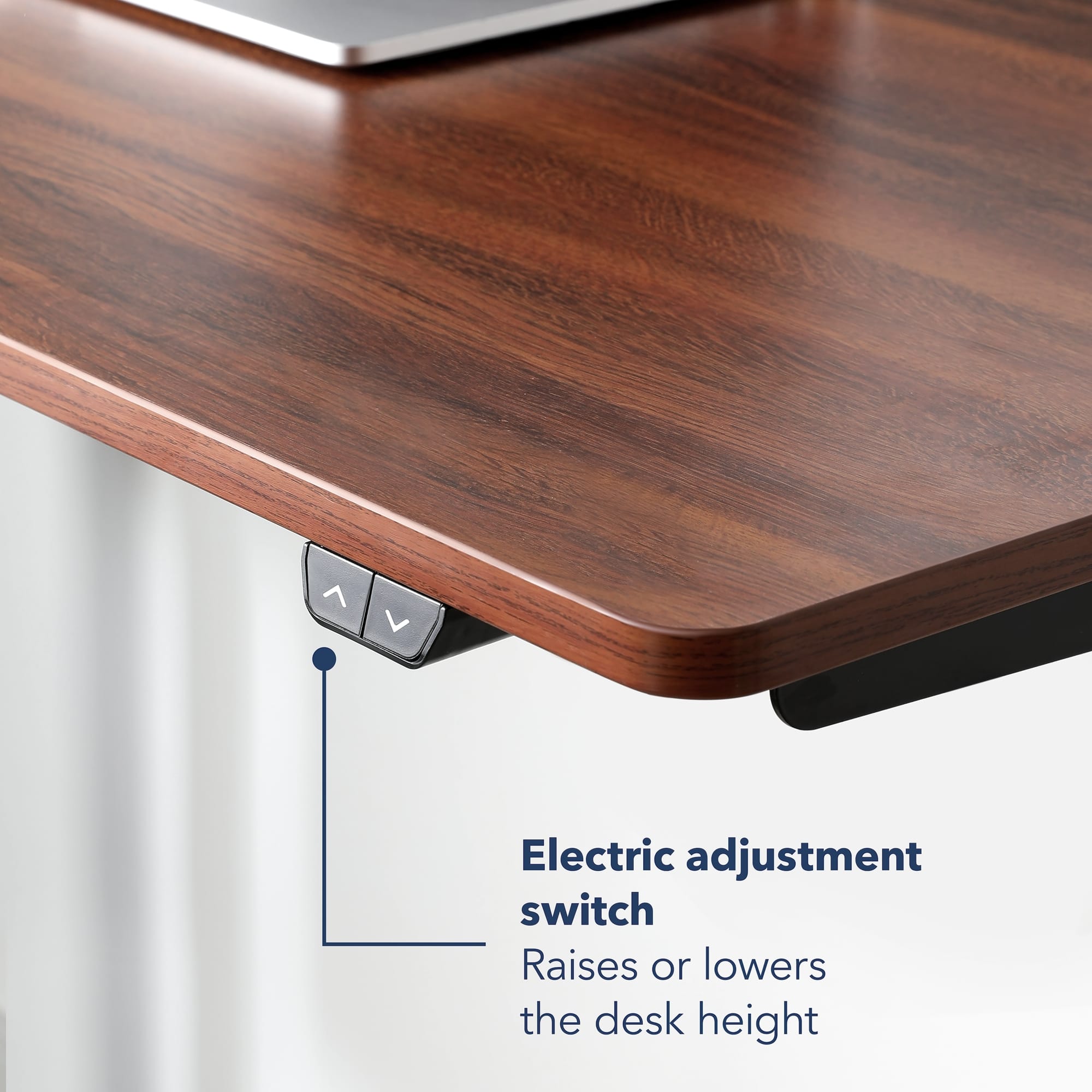 The image shows a wooden desk with a laptop on it. The desk has an electric adjustment switch that allows the user to raise or lower the desk height. This feature is particularly useful for ergonomics and comfort while working at the desk.