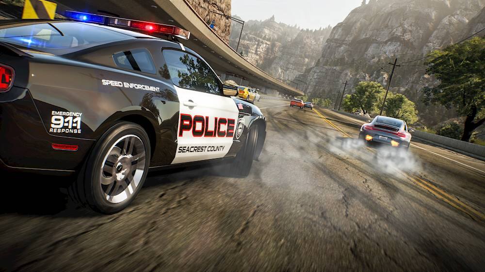 The image features a police car with the word "Police" written on it, driving down a road. The car is positioned on the left side of the image, and there are other cars in the scene as well. The police car is likely responding to an emergency or performing speed enforcement duties.