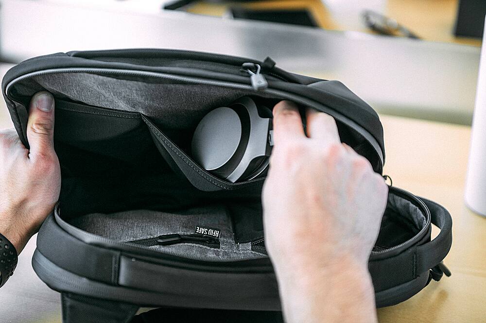 The text "SAFE RFID" is not present in the image. The image shows a person holding a backpack and looking inside it.