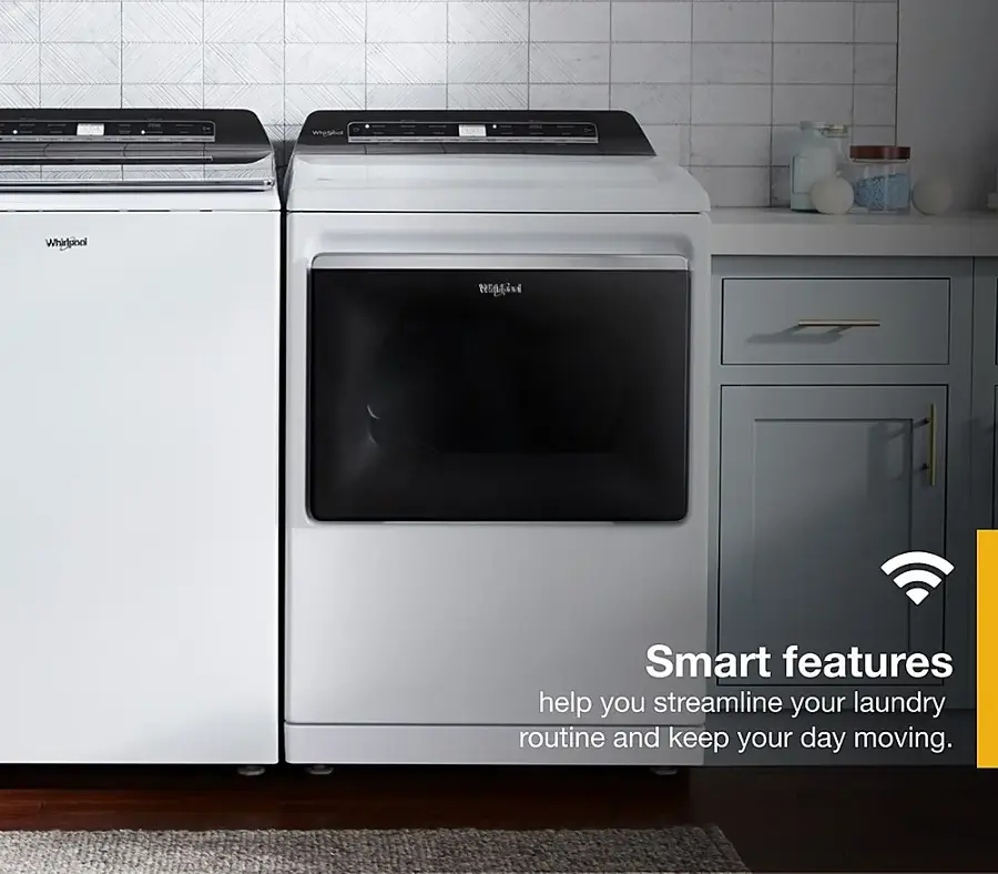 The image features a kitchen with two washing machines, one on the left and one on the right. The washing machines are white and have a black door. The kitchen also has a sink and a couple of bottles. The advertisement for the washing machines highlights their smart features, which help streamline the laundry routine and keep the day moving.